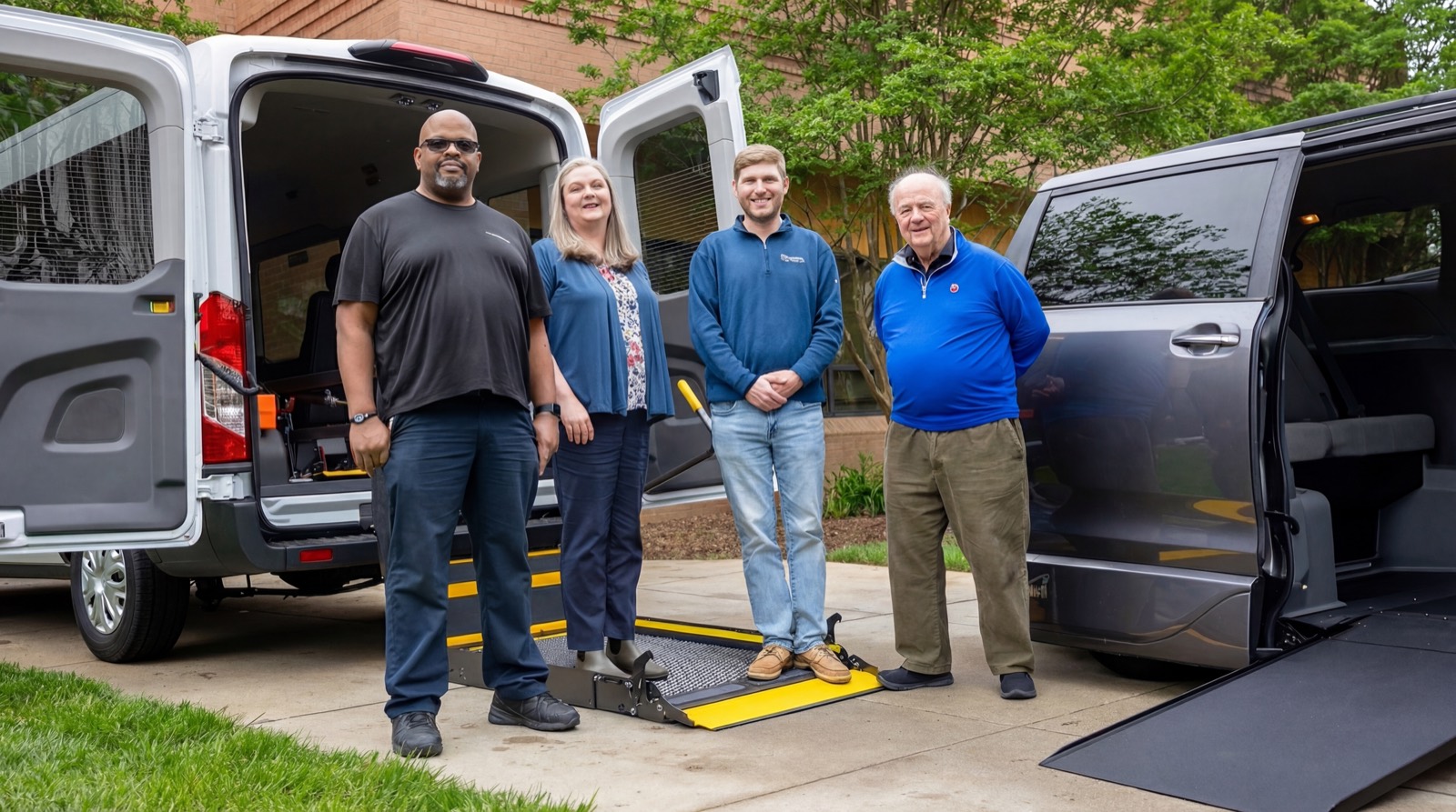 The Apple Mobility team beside wheelchair-accessible vans at the Columbia, Maryland headquarters