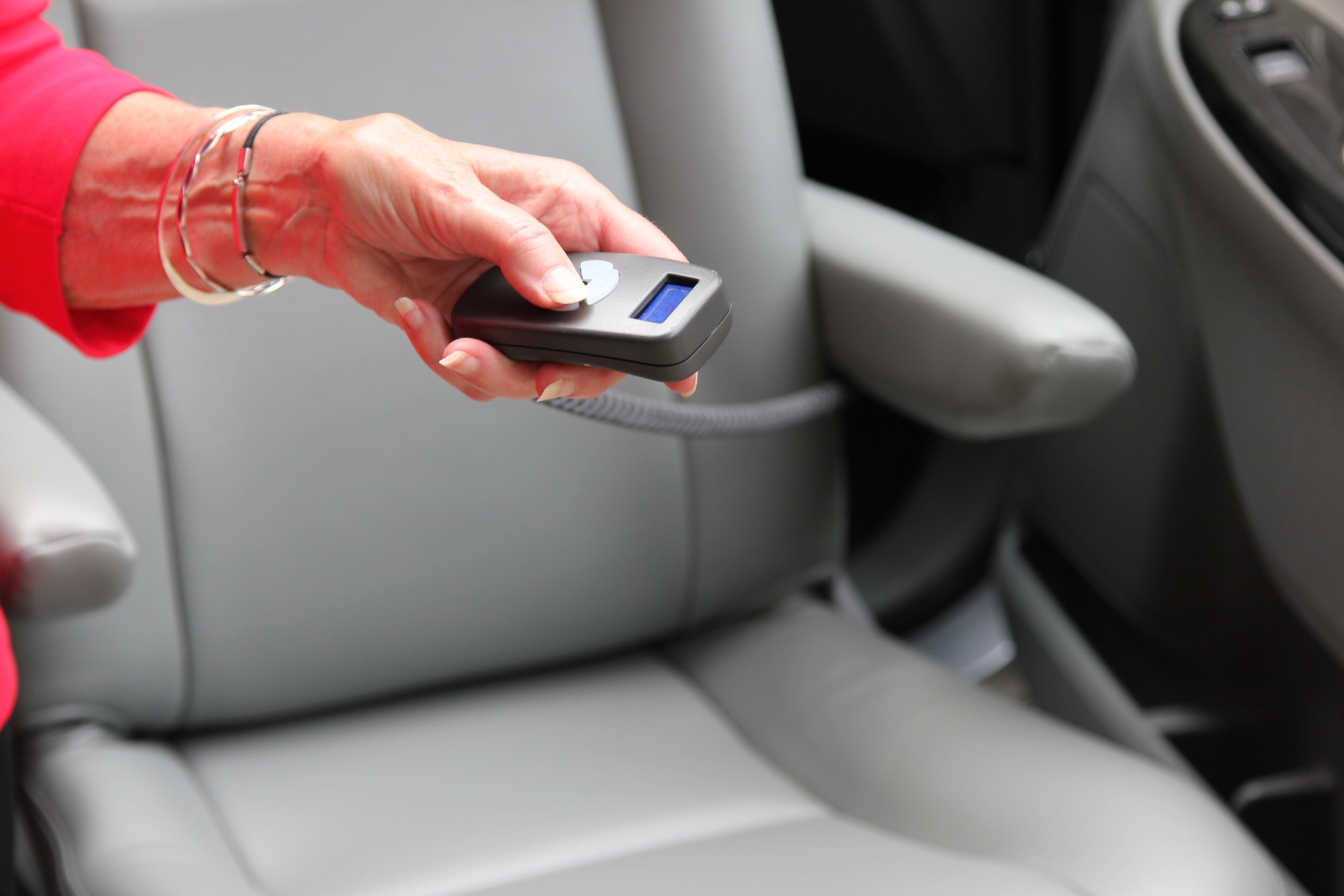 A hand holding the small wireless remote control that operates the Turny Evo seat motion.